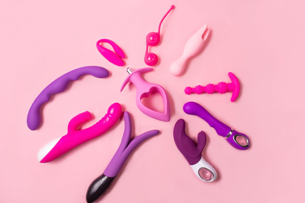 Juguetes para adultos sobre fondo rosa, conjunto sexual.
